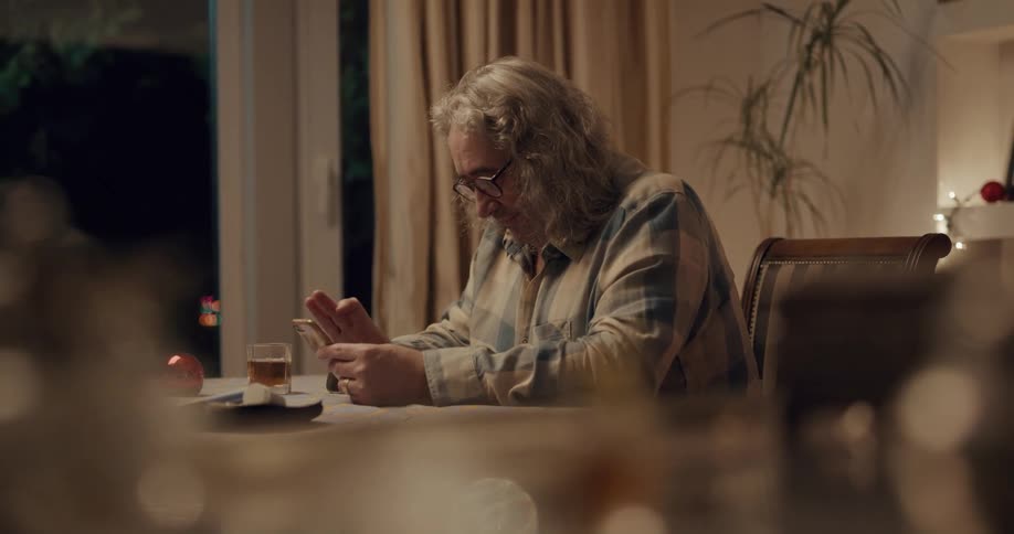 A man waves goodbye on his cell phone