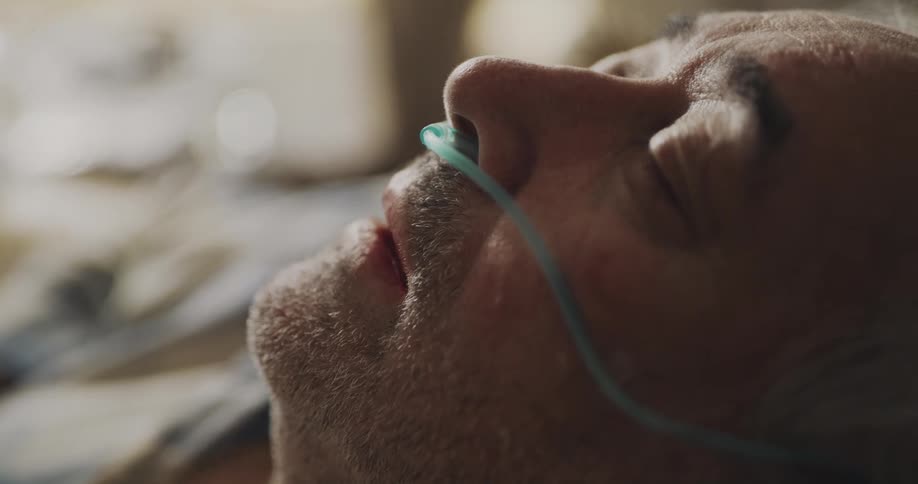 An elderly man sleeping with a breathing tube