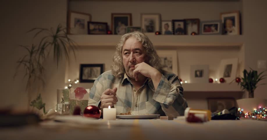 A man is sitting at the kitchen table and eating dinner