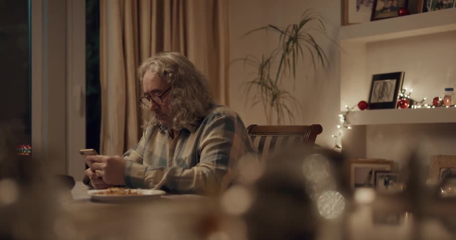 Person is on phone and eating some dinner