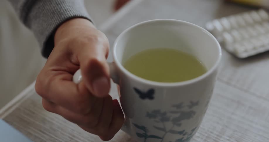 A person lifts a cup of tea
