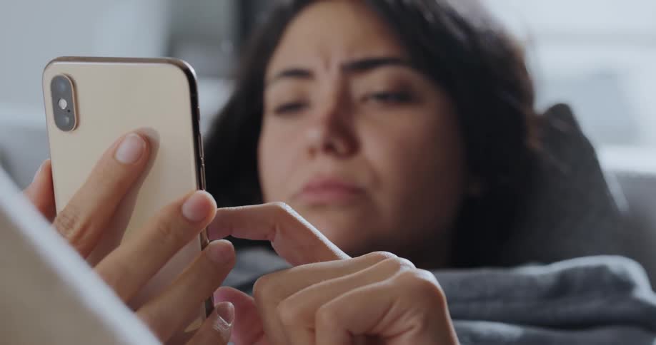 A woman is resting and looking at her cell phone