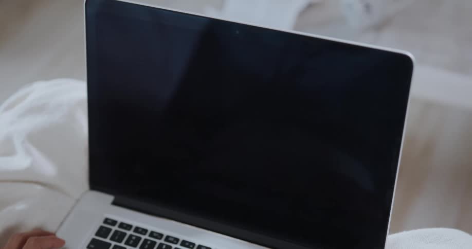 A person is laying down and browsing on their laptop