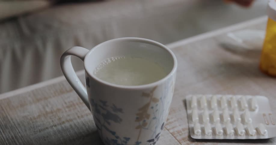 Woman places an effervescent tablet inside a cup of water