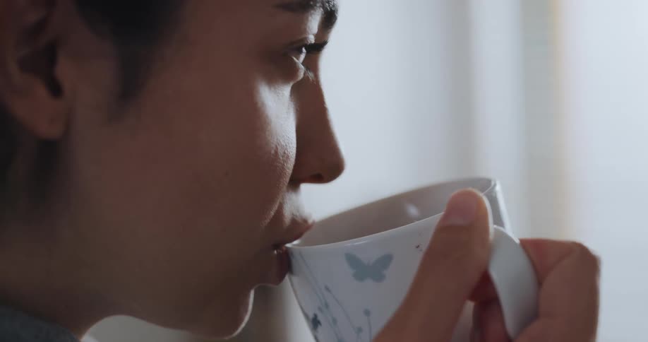A woman drinks from a mug