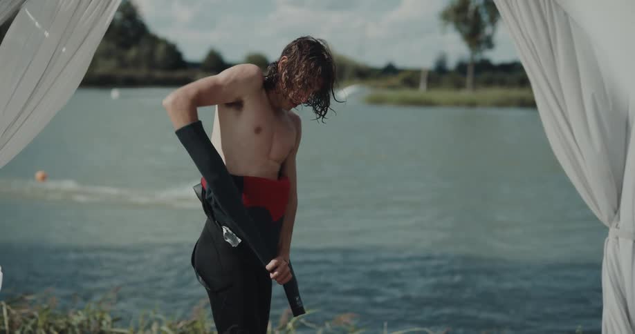 Man is taking off his swim suit
