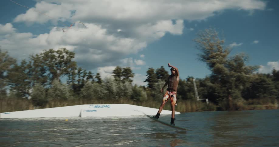 A man jumps off the ramp on as he windsurfs