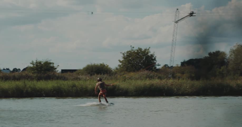 A man waterskiing goes up a ramp and does a flip