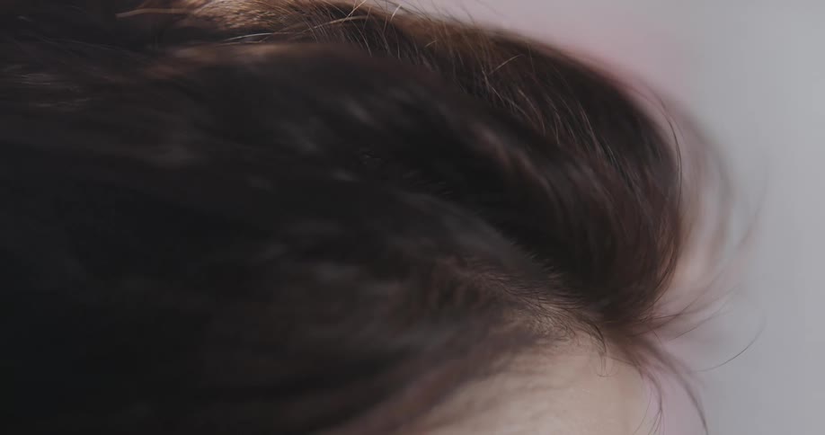 Close up view of a womans hair is displayed