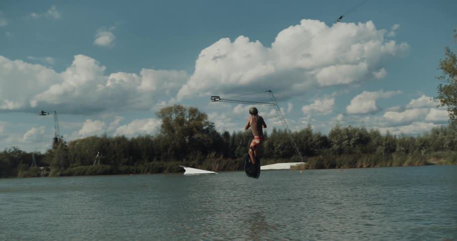 Young man is doing tricks on the lake