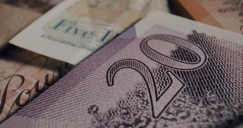 The number on a banknote lying atop a pile of money