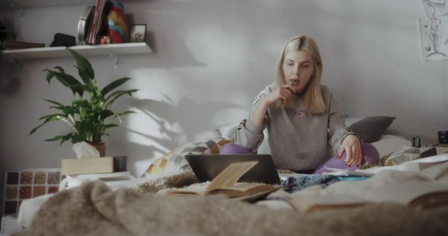 Young blond woman is sitting on the bed