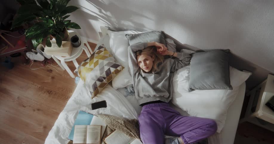 Young woman is laying down on the bed