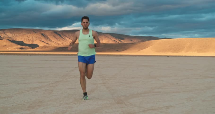 Young man is jogging on the desert