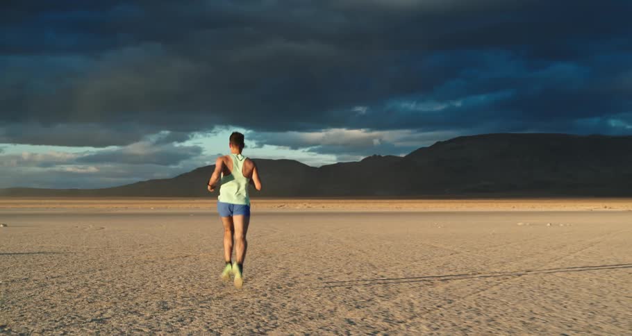 A man runs through a wide open desert