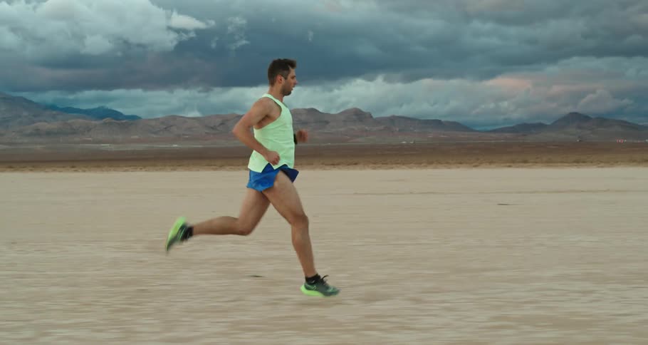 Young man is running at the desert