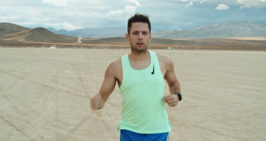 Young white man is jogging outside on the desert