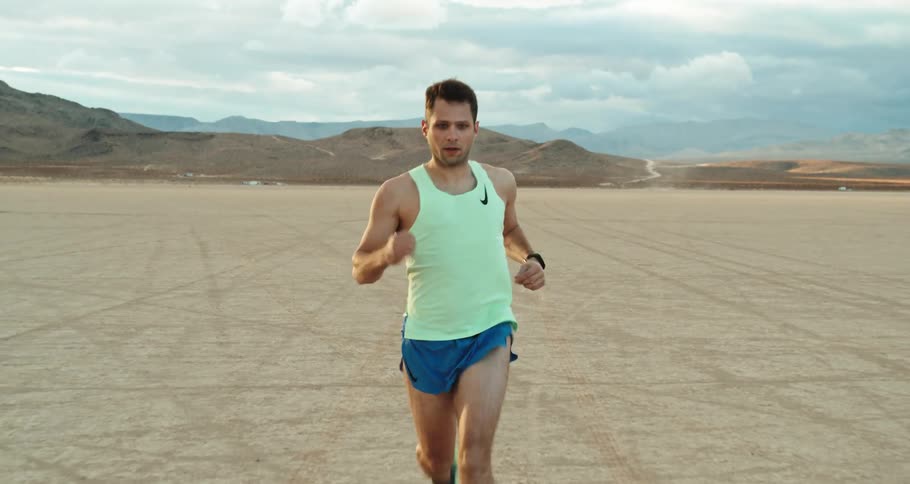 A man is jogging outdoors in an open landscape