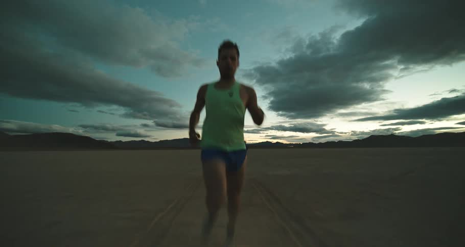 A man is jogging outdoors in a desert area