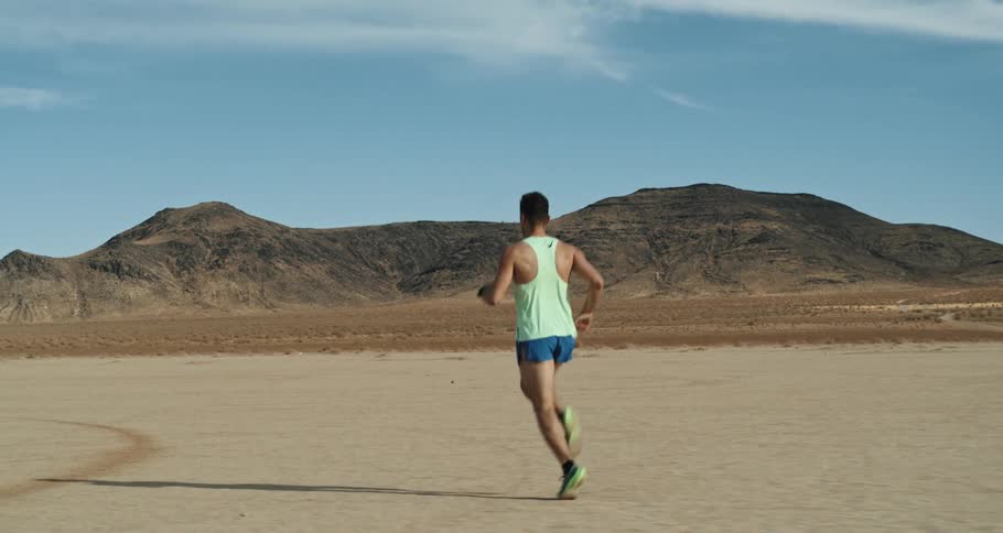 Young man is jogging outside on the desert