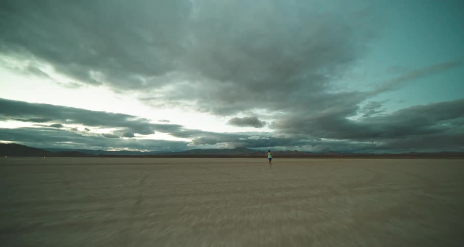 A jogger runs through a wide open empty field