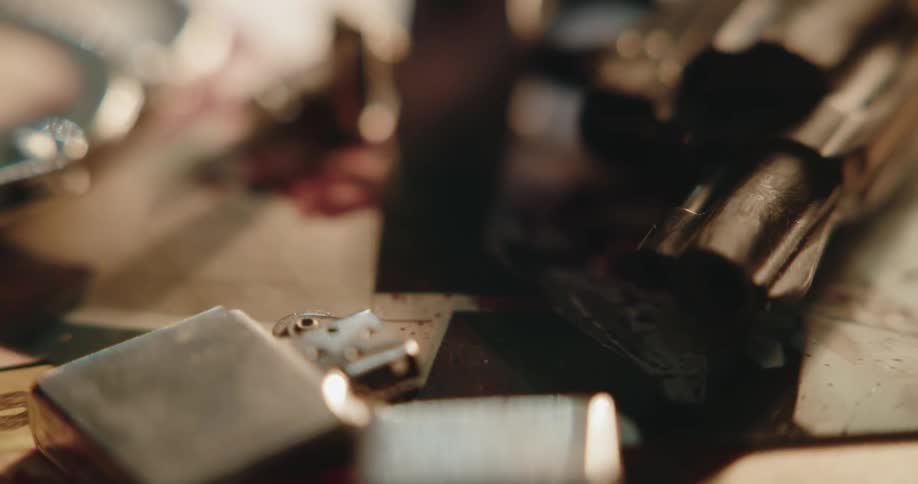 A revolver and a lighter resting over photographs on a desk