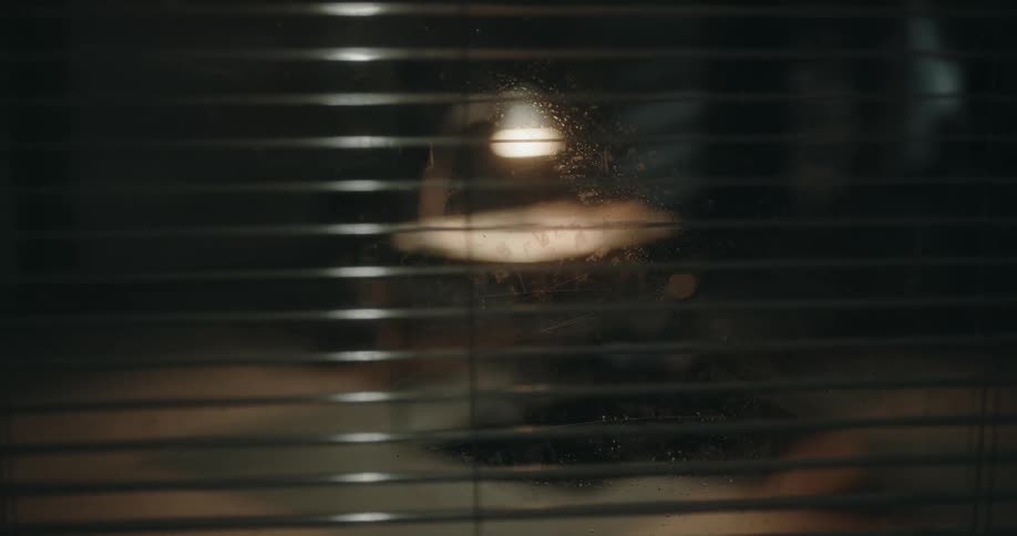Dark obscure interrogation room behind a window with shades