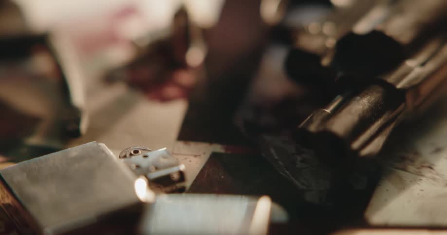A view of a gun and lighter on a table
