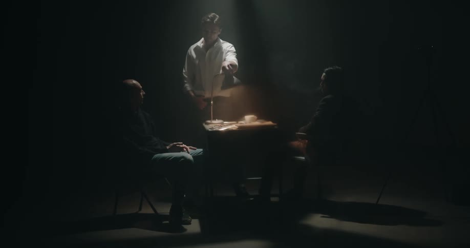 Detective in an interrogation room shines a bright light on a suspects face