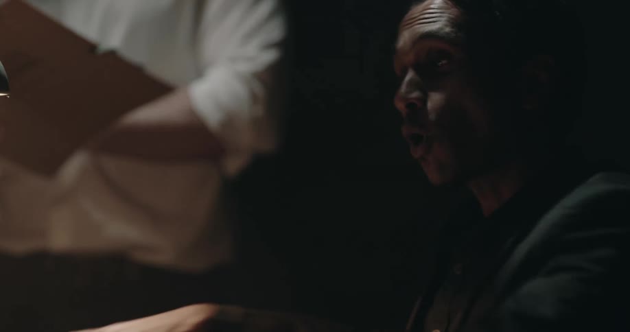 The officer is interrogating a man