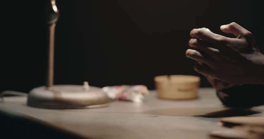 A man is sitting at a table and holding a recorder