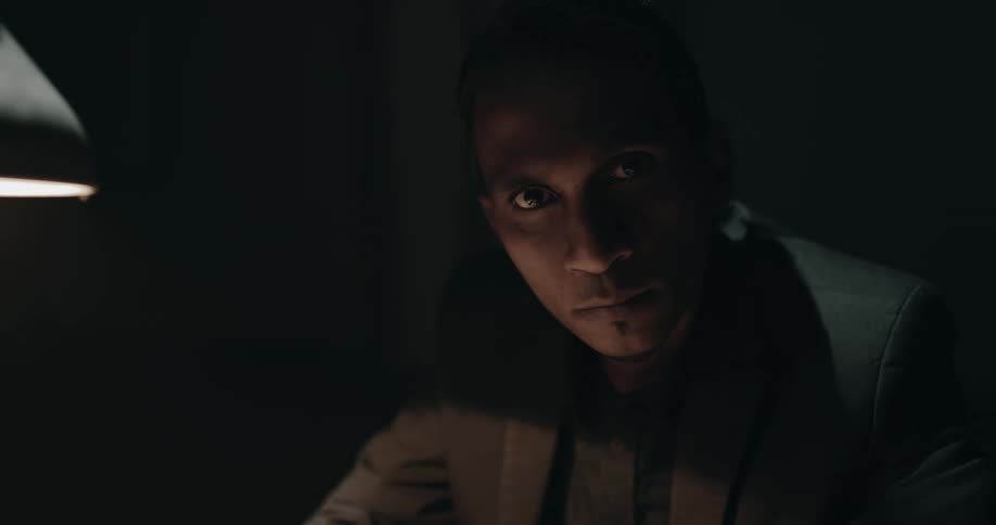 A detective looks up and over while in an interrogation room