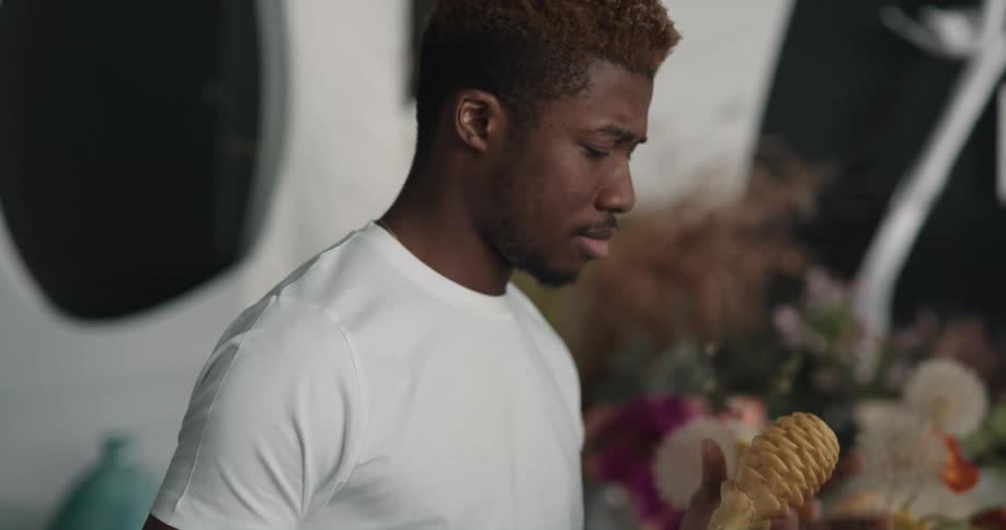 Man working on a shop smells an exotic flower