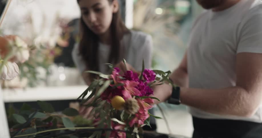 Employees of a flower shop arranging a bouquet together