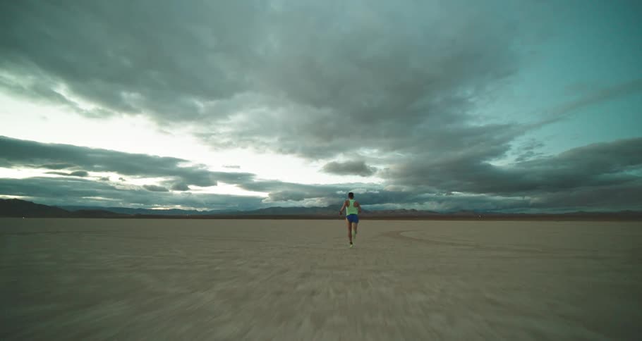 Young man is running outside at the desert