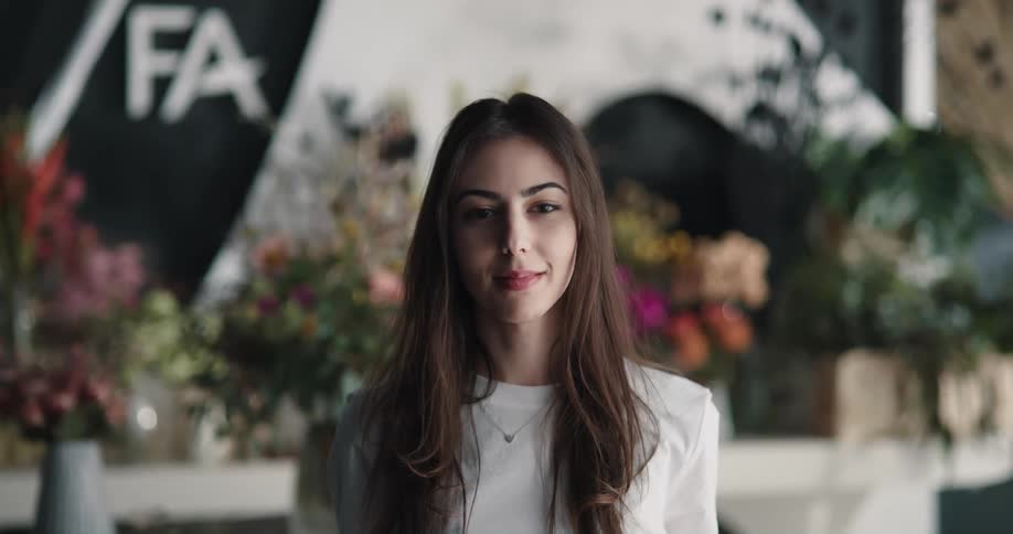 Young female employee of a flower shop looking at the camera