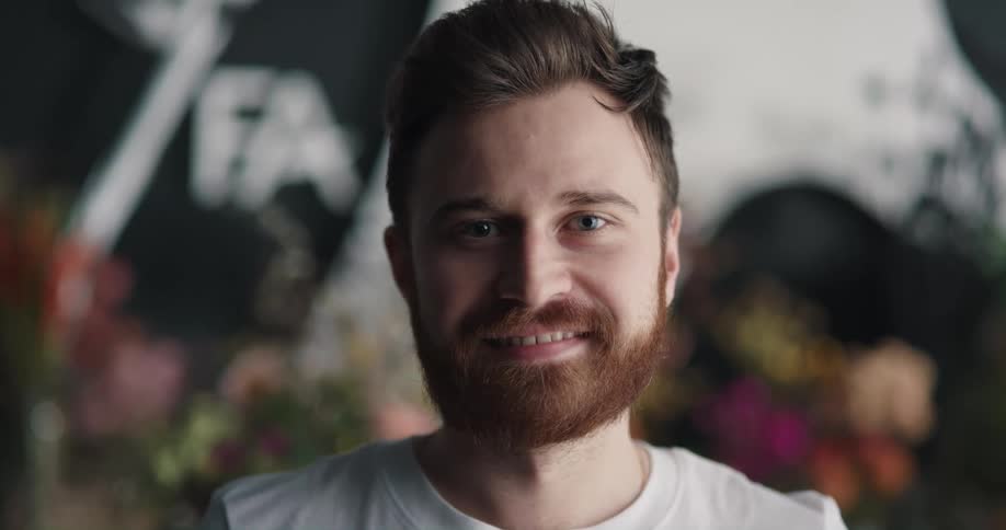 A man turns his head to smile into the camera
