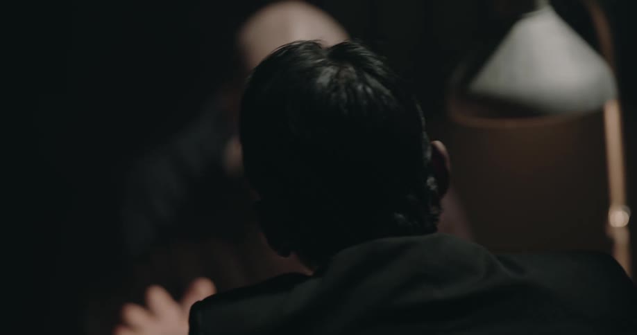 Man interrogates suspect sitting on a chair inside an interrogation room