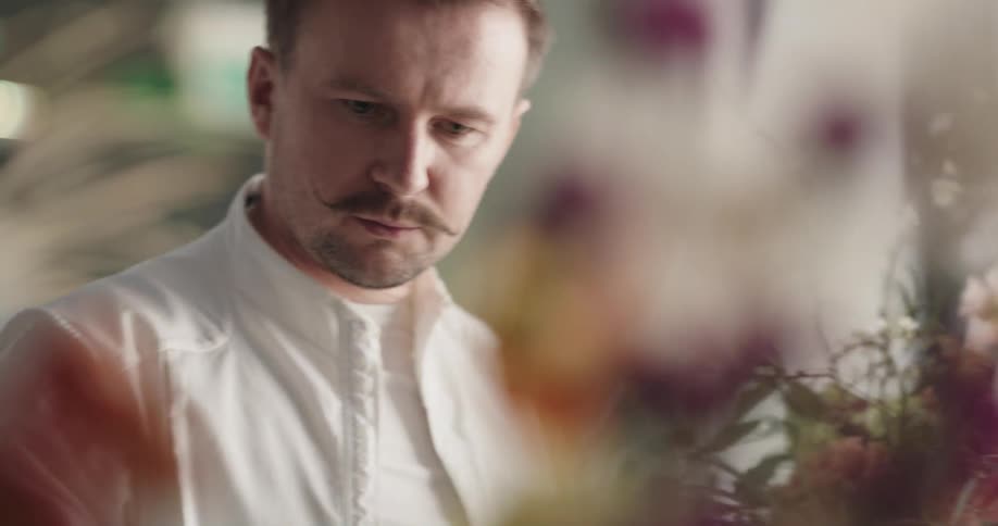 A man is gathering flowers into a bouquet