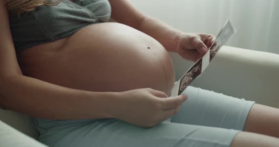 Pregnant woman is sitting on a chair