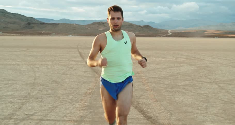 A man jogs through a flatland in a desert during the day