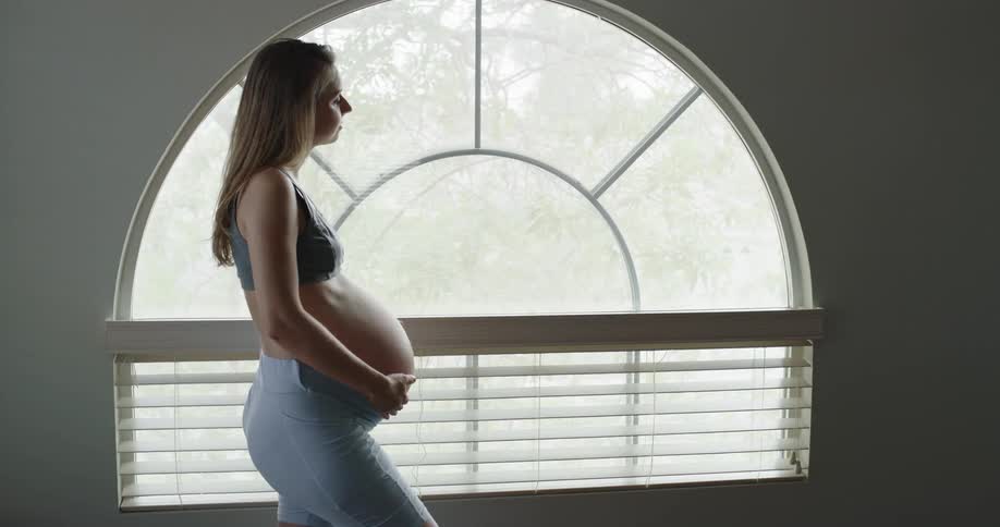 Young pregnant woman is rubbing her belly
