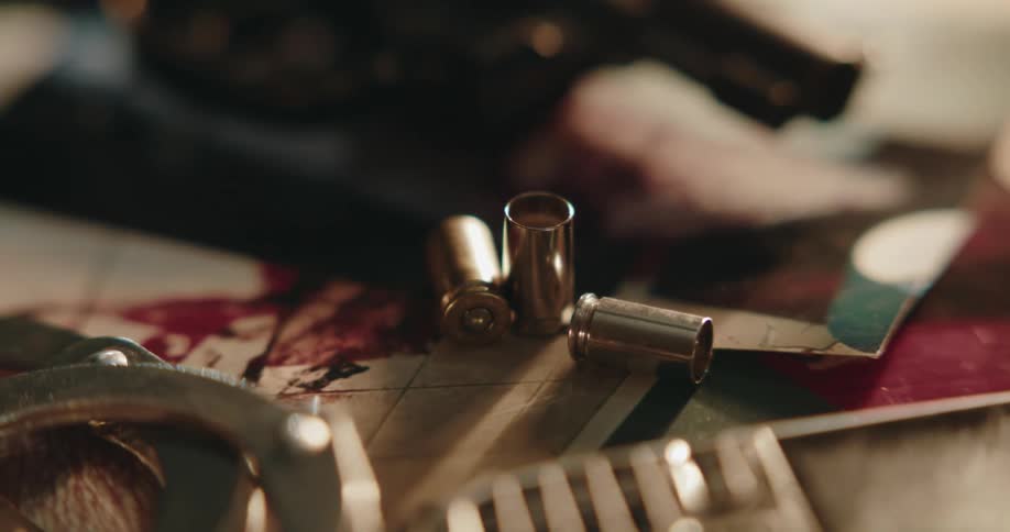 Shell casings and handcuffs sit on photos of a crime scene