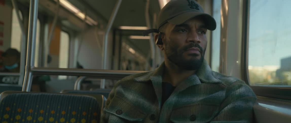 A man rides a bus while wearing wireless earbuds