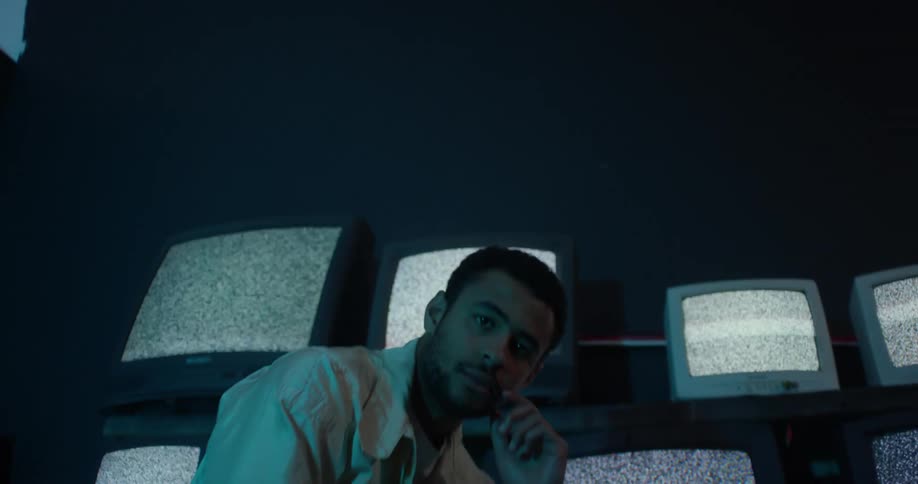 Young man is sitting down on a television