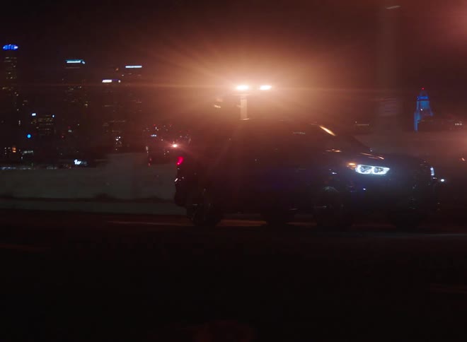 A car is driving through a downtown city at night
