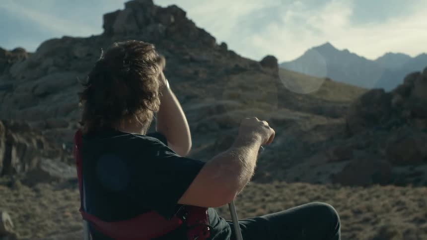 Man is sitting down smoking a cigarette