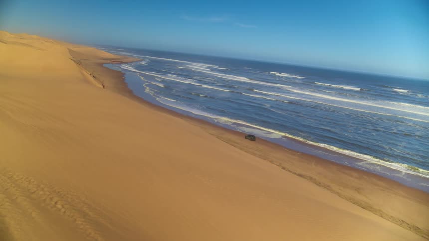 Car driving along the desert coastline in Namibia