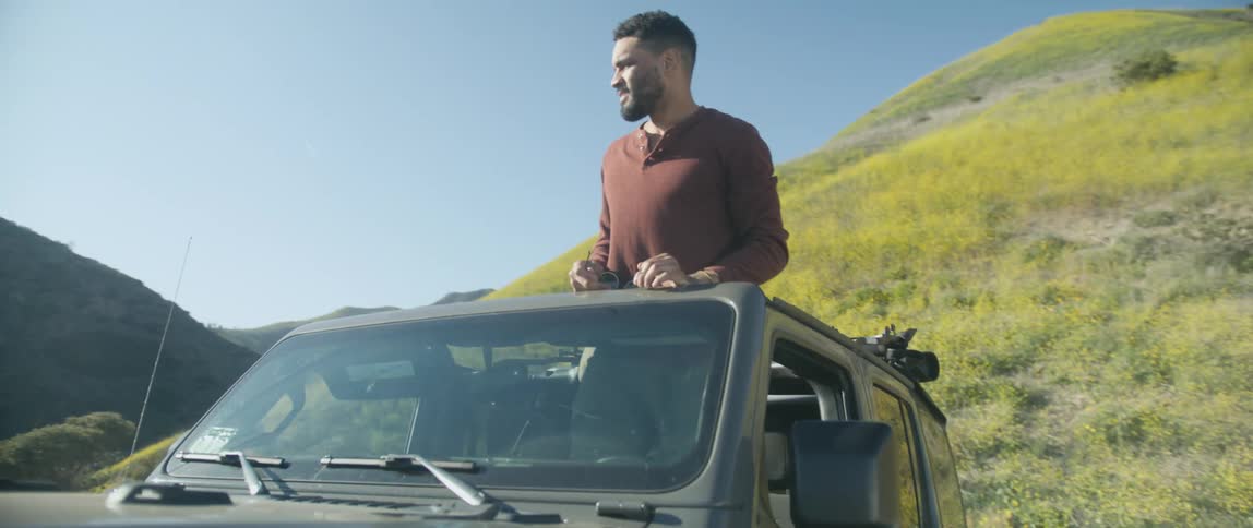 Man is standing up in a truck outdoors