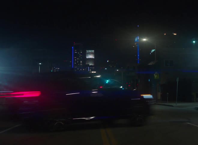 Cars are driving downtown at night